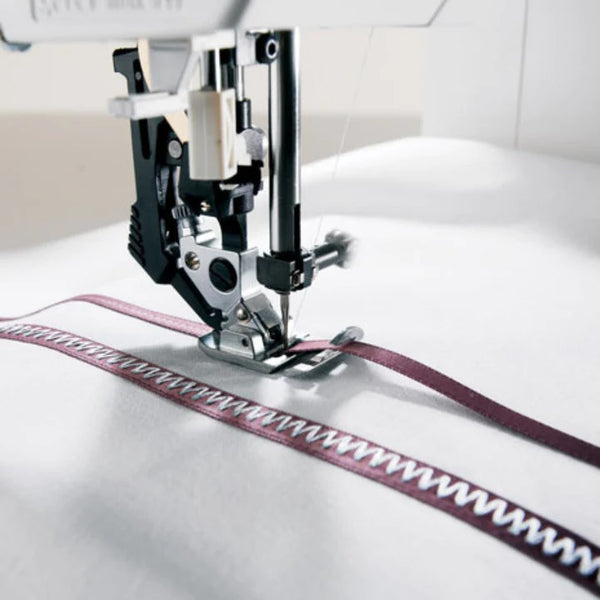 pfaff expression 710 idt system sewing a ribbon to white cloth.